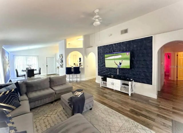 living room featuring hardwood / wood-style flooring, vaulted ceiling, and ceiling fan