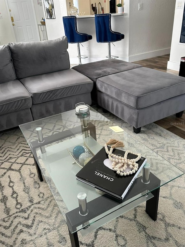 living room with hardwood / wood-style floors and sink