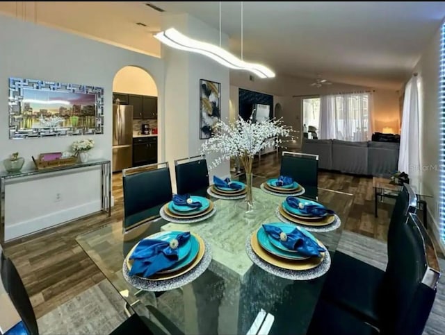 dining room featuring dark hardwood / wood-style floors, vaulted ceiling, and ceiling fan