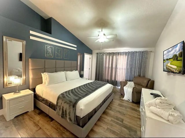 bedroom with ceiling fan, vaulted ceiling, and light hardwood / wood-style flooring