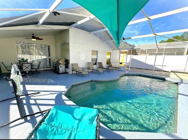 view of swimming pool with a lanai, ceiling fan, and a patio area