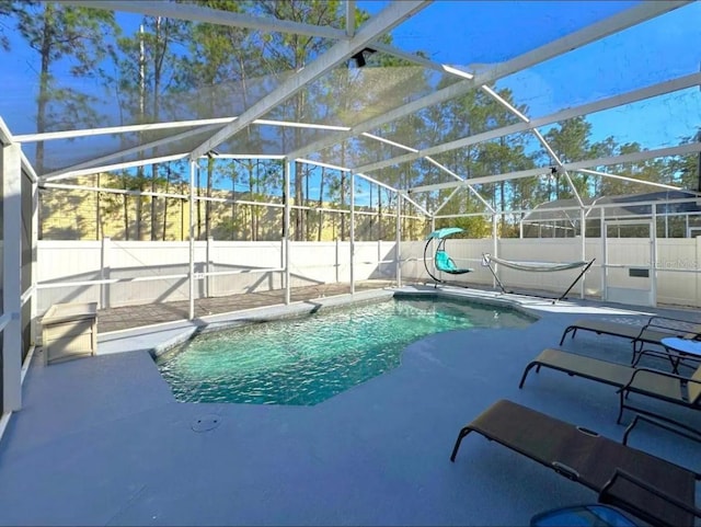 view of pool with glass enclosure and a patio