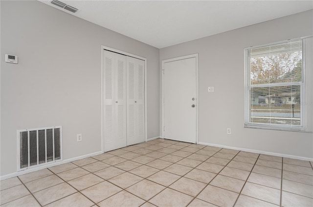 unfurnished bedroom featuring a closet and light tile patterned floors