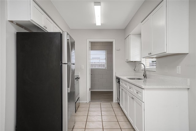 kitchen featuring sink, white cabinetry, stainless steel appliances, and light tile patterned flooring