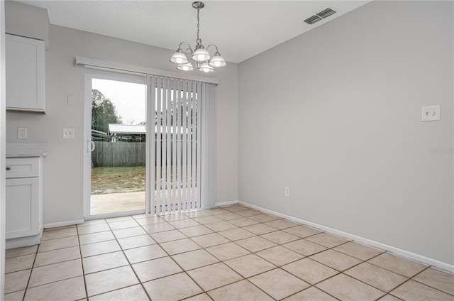 unfurnished dining area with a chandelier and light tile patterned flooring