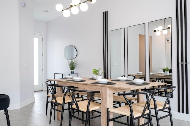 dining space featuring light tile patterned flooring and an inviting chandelier