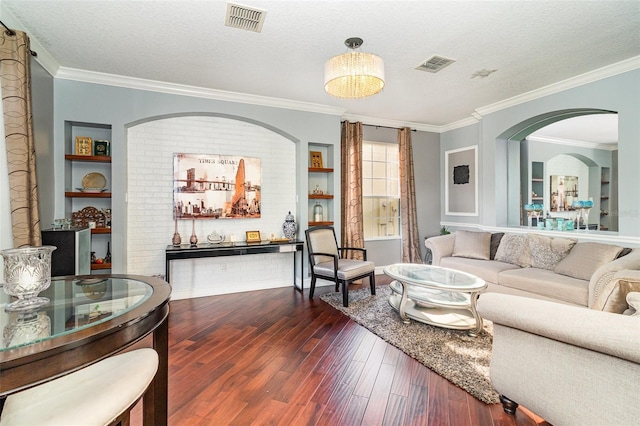 living room with dark hardwood / wood-style floors, a textured ceiling, and ornamental molding