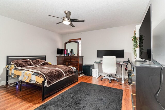 bedroom featuring a textured ceiling, light wood-type flooring, and ceiling fan