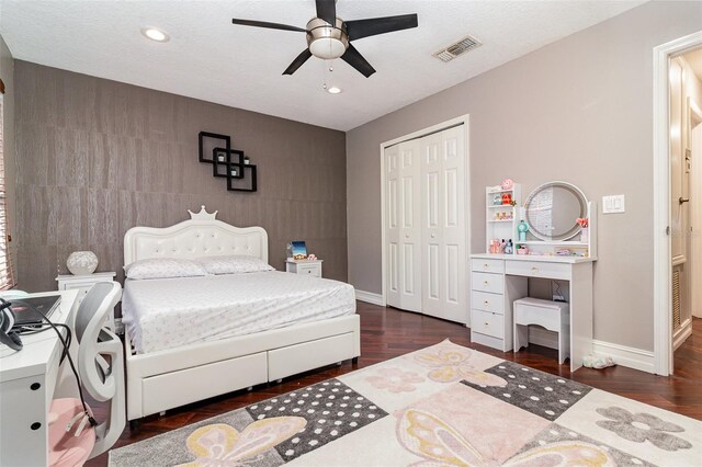 bedroom with dark hardwood / wood-style flooring, ceiling fan, a closet, and a textured ceiling