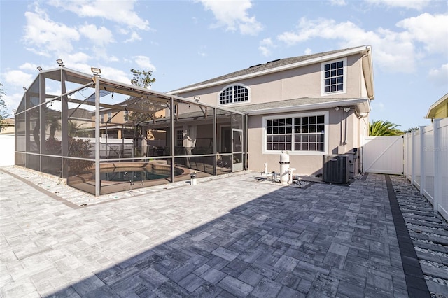 back of house with a patio area, a lanai, central air condition unit, and a pool