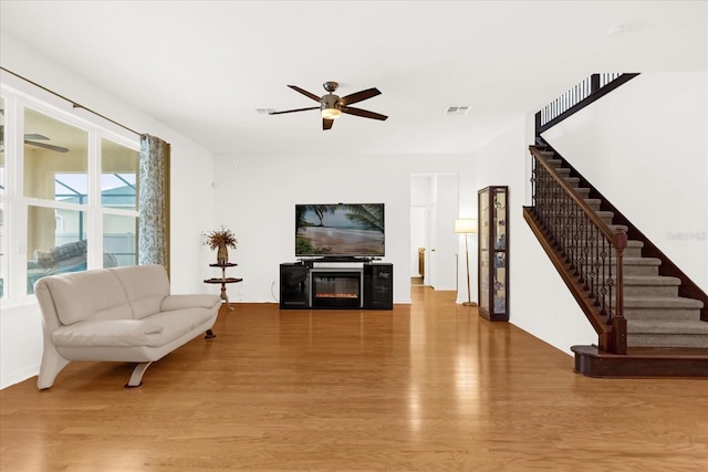 living room with ceiling fan and light hardwood / wood-style floors