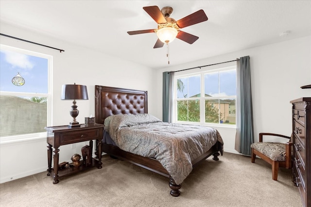 carpeted bedroom with multiple windows and ceiling fan