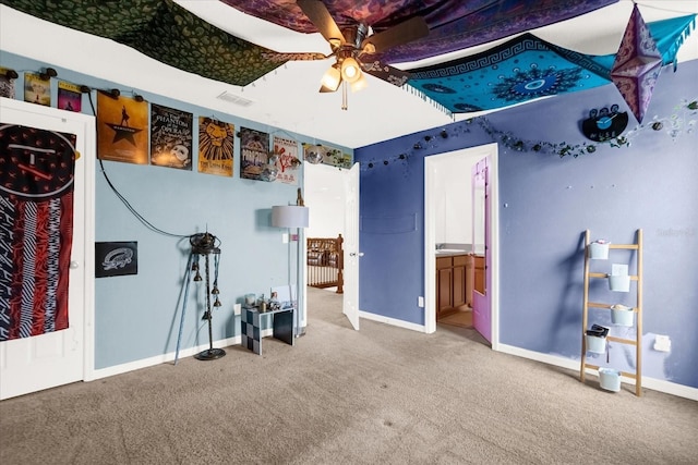 interior space featuring carpet flooring, ceiling fan, and ensuite bathroom