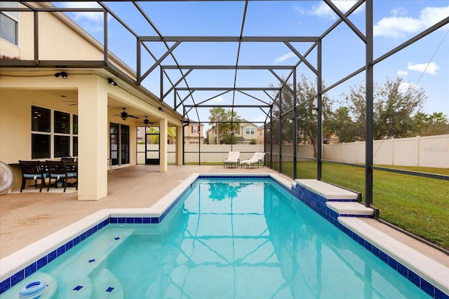 view of pool with a lanai, a patio area, ceiling fan, and a yard