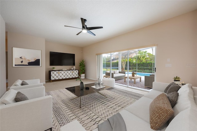 carpeted living room featuring ceiling fan and a textured ceiling