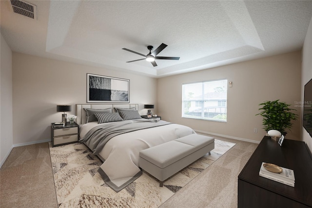 carpeted bedroom featuring ceiling fan, a textured ceiling, and a tray ceiling