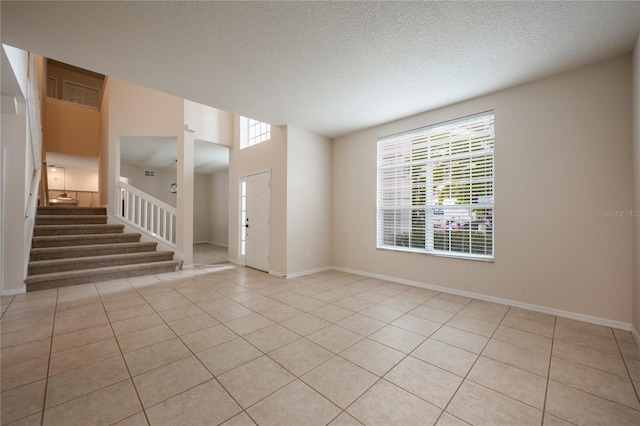 spare room featuring light tile patterned floors, a textured ceiling, and a wealth of natural light