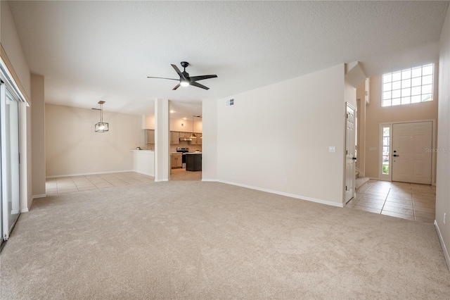 unfurnished living room with ceiling fan and light colored carpet