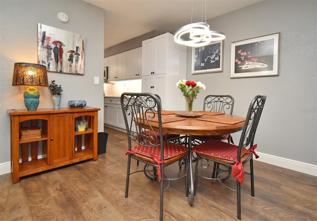 dining room with hardwood / wood-style flooring and an inviting chandelier