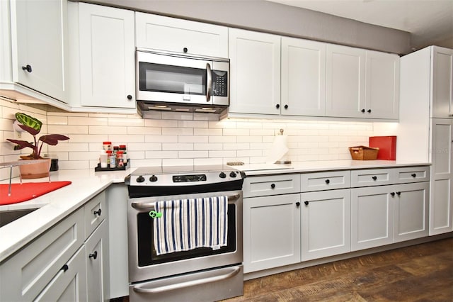 kitchen featuring appliances with stainless steel finishes, backsplash, dark hardwood / wood-style floors, and white cabinetry