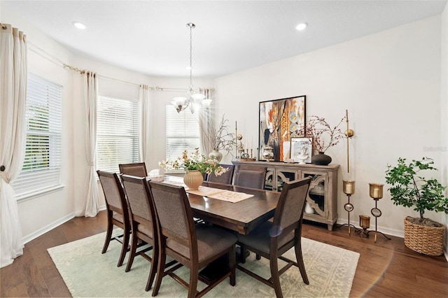 dining area with dark hardwood / wood-style floors and an inviting chandelier