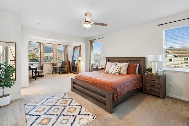 bedroom with light carpet, multiple windows, and ceiling fan