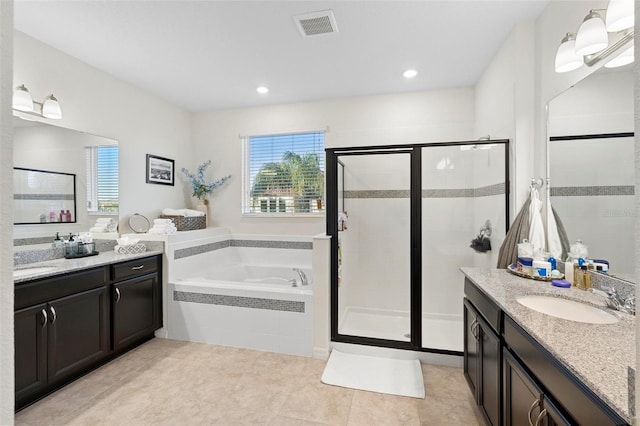 bathroom with tile patterned flooring, vanity, a healthy amount of sunlight, and plus walk in shower