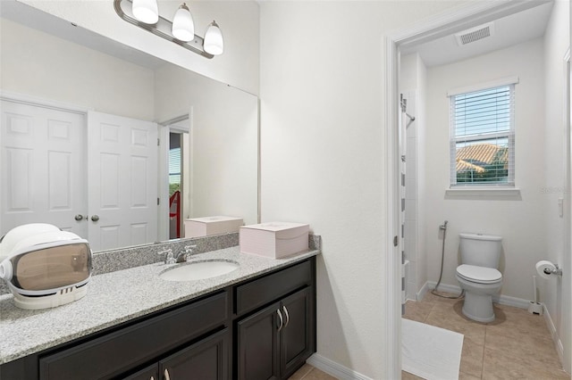 bathroom with tile patterned flooring, vanity, and toilet