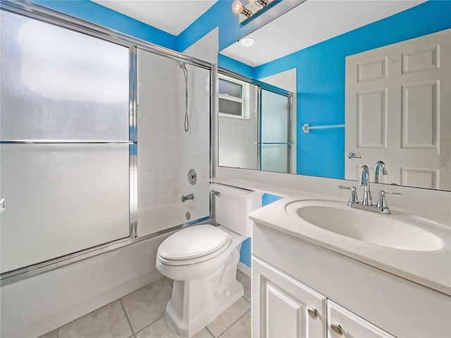 full bathroom with combined bath / shower with glass door, vanity, tile patterned floors, and toilet