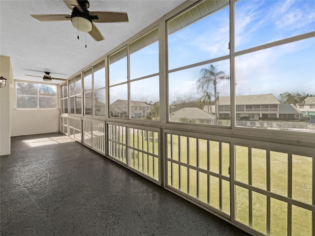 unfurnished sunroom with ceiling fan