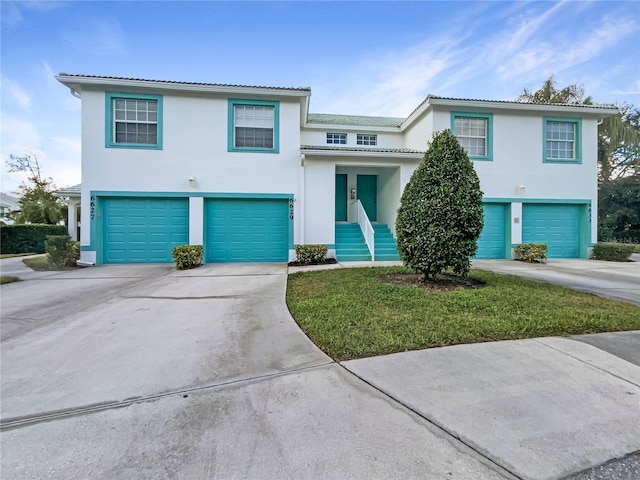 6629 Pineview Ter Unit 5-201, Bradenton, FL 34203 - view of front of home featuring a garage, driveway, stucco siding, and a tile roof