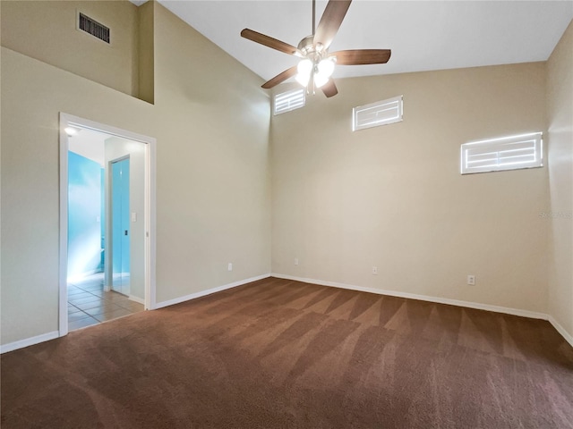 empty room featuring ceiling fan, light colored carpet, and high vaulted ceiling