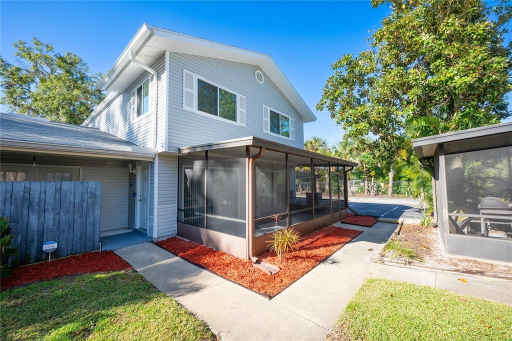 rear view of house featuring a sunroom