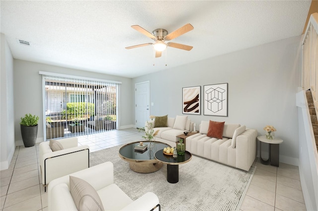 tiled living room with a textured ceiling and ceiling fan