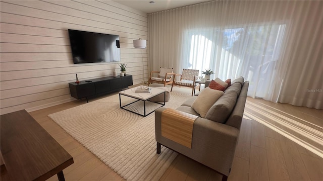 living room with wood walls and light wood-type flooring