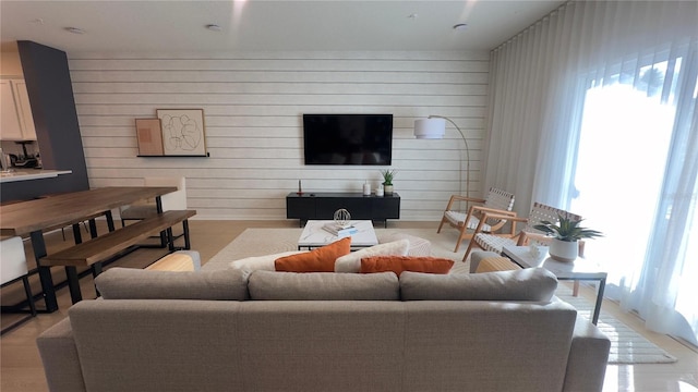 living room with light hardwood / wood-style floors and wooden walls