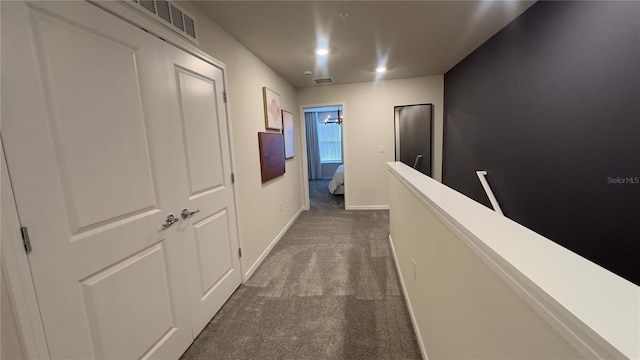 corridor featuring dark colored carpet