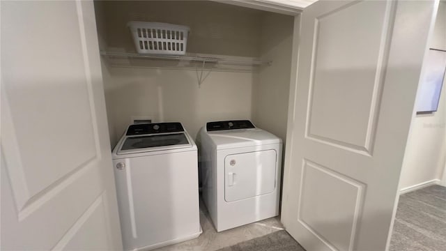 clothes washing area with separate washer and dryer and light carpet