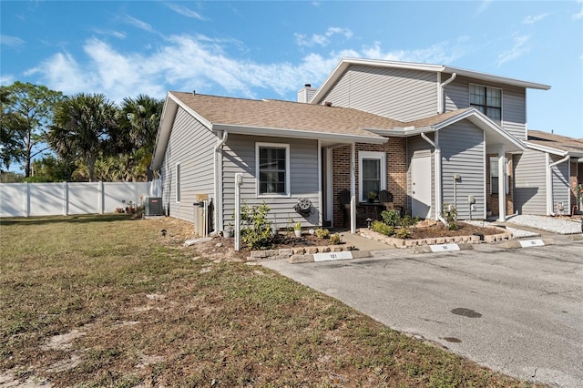 view of property with cooling unit and a front lawn