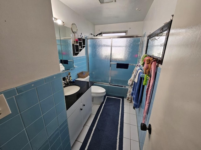 full bathroom with vanity, tile walls, enclosed tub / shower combo, tile patterned flooring, and toilet