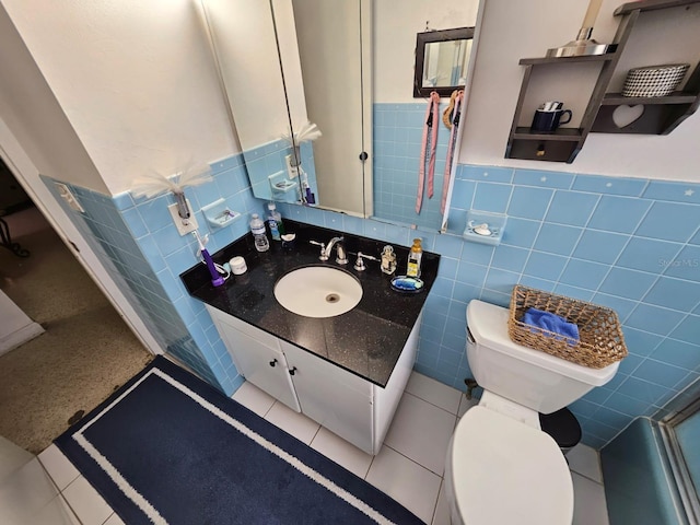 bathroom featuring tile patterned flooring, vanity, and tile walls