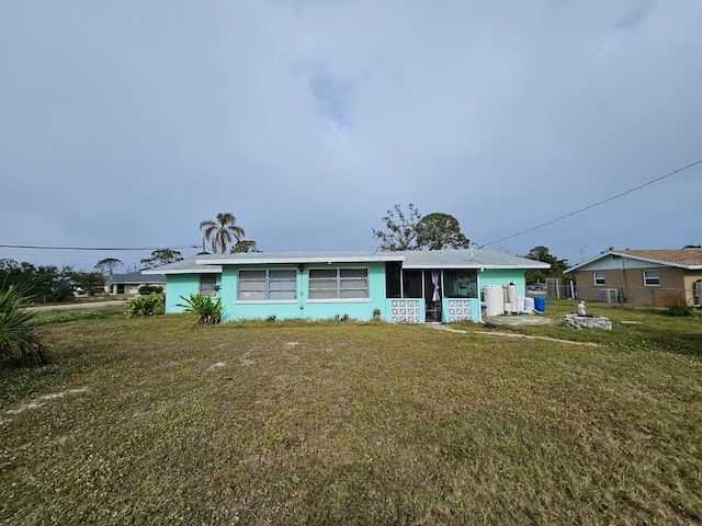 single story home with a sunroom and a front yard