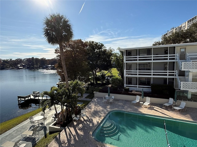 view of swimming pool featuring a patio area and a water view