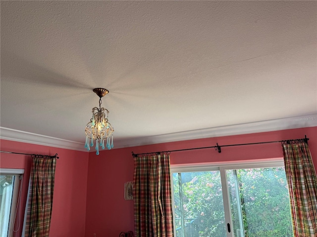 room details featuring a chandelier, a textured ceiling, and crown molding