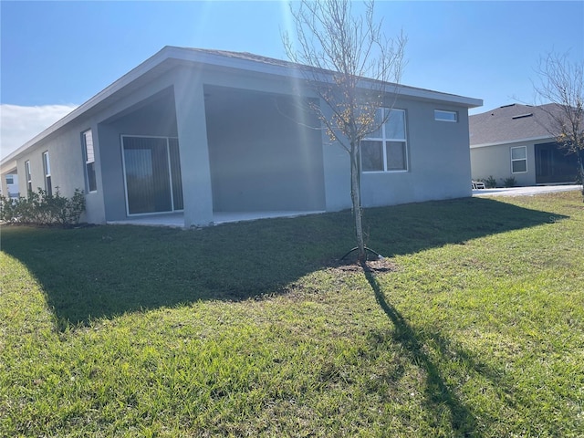 view of side of home with a yard