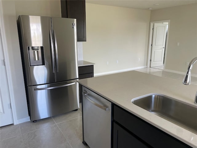 kitchen featuring light tile patterned floors, appliances with stainless steel finishes, and sink