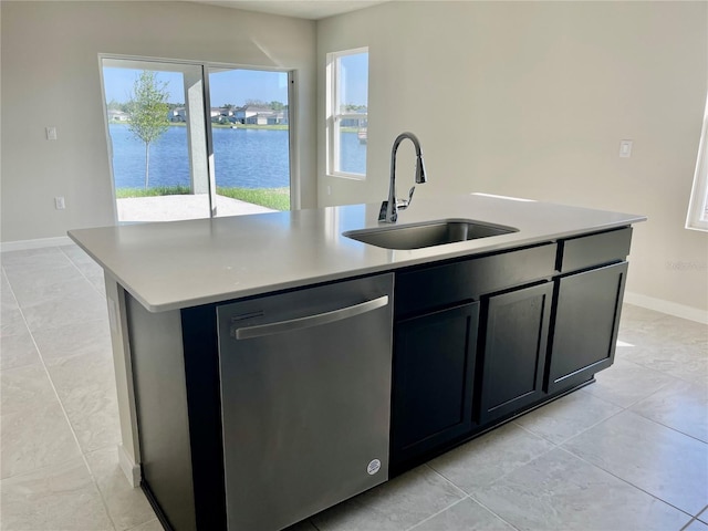 kitchen with sink, stainless steel dishwasher, a kitchen island with sink, and a water view