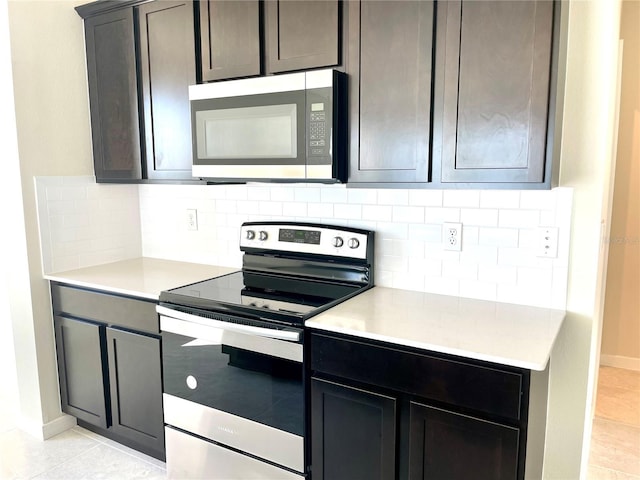 kitchen with light tile patterned floors, decorative backsplash, appliances with stainless steel finishes, and dark brown cabinetry