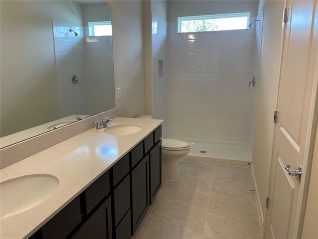 bathroom featuring toilet, a shower, tile patterned floors, and vanity