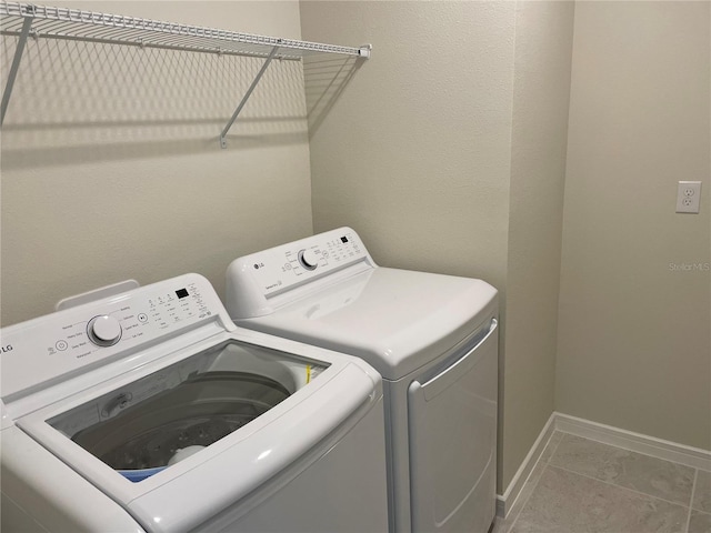 clothes washing area with tile patterned flooring and independent washer and dryer